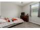 Bedroom featuring neutral carpet, a window, and dark dresser next to a bed at 12357 W Whyman Ave, Avondale, AZ 85323