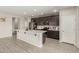 Modern kitchen with a large island, dark cabinets, stainless steel appliances and tile floors at 12357 W Whyman Ave, Avondale, AZ 85323
