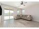 Cozy living room featuring neutral walls, tile floors, a sectional sofa and a sliding door to the backyard at 12357 W Whyman Ave, Avondale, AZ 85323