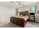 Bedroom features a ceiling fan, two windows, and a large wooden bed frame at 12357 W Whyman Ave, Avondale, AZ 85323