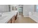 Bright primary bathroom with white countertops, double sinks, and views of the soaking tub at 1258 W Plane Tree Ave, San Tan Valley, AZ 85140