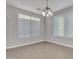 Neutral dining area with tile floors, chandelier lighting, and natural light from two windows at 1258 W Plane Tree Ave, San Tan Valley, AZ 85140