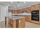 Spacious kitchen with granite countertops, stainless appliances, and island with sink at 1258 W Plane Tree Ave, San Tan Valley, AZ 85140