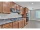 Granite countertops, stainless vent hood, and stovetop complement the modern kitchen design at 1258 W Plane Tree Ave, San Tan Valley, AZ 85140