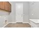 Bright laundry room with cabinets, tiled floors, utility sink, and back door at 1258 W Plane Tree Ave, San Tan Valley, AZ 85140