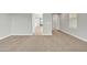 Bright and airy living room featuring neutral paint, tan carpet, and entry to adjacent rooms at 1258 W Plane Tree Ave, San Tan Valley, AZ 85140