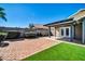 Backyard features artificial turf, brickwork, and a covered patio at 13233 W Mauna Loa Ln, Surprise, AZ 85379