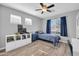Bright bedroom with a ceiling fan, two windows, simple decor and wood floors at 13233 W Mauna Loa Ln, Surprise, AZ 85379