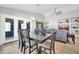 Elegant dining area with wood-look floors, a modern light fixture, and sliding glass doors to the backyard at 13233 W Mauna Loa Ln, Surprise, AZ 85379