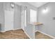 Bright entryway featuring wood-look floors, a built-in desk, and a view of the front door and coat closet at 13233 W Mauna Loa Ln, Surprise, AZ 85379