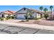 Inviting single-story home featuring a two-car garage, mature trees, and attractive front yard landscaping at 13233 W Mauna Loa Ln, Surprise, AZ 85379