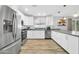 Well-lit kitchen with stainless steel appliances, white cabinets, and a large island with pendant lighting at 13233 W Mauna Loa Ln, Surprise, AZ 85379