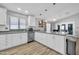 Spacious kitchen with stainless steel appliances, white cabinets and a large counter overlooking the dining area at 13233 W Mauna Loa Ln, Surprise, AZ 85379