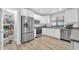 Modern kitchen featuring stainless steel appliances, white cabinetry, and ample counter space for cooking at 13233 W Mauna Loa Ln, Surprise, AZ 85379