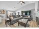 Cozy living area with a large grey sectional, decorative fireplace, and open access to the dining area at 13233 W Mauna Loa Ln, Surprise, AZ 85379