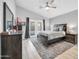 This main bedroom features a ceiling fan, light wood flooring, and access to the backyard at 13233 W Mauna Loa Ln, Surprise, AZ 85379