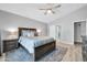 This main bedroom includes a ceiling fan, wood flooring, and an ensuite bathroom at 13233 W Mauna Loa Ln, Surprise, AZ 85379
