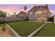 Spacious backyard with green grass, block wall, and a tiled patio offering lots of potential at 1433 E Mineral Rd, Gilbert, AZ 85234