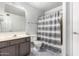 This bathroom features a shower with gray striped shower curtain, tile floors and painted vanity at 1433 E Mineral Rd, Gilbert, AZ 85234