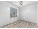 The neutral bedroom features a ceiling fan, large window, and plank flooring at 1433 E Mineral Rd, Gilbert, AZ 85234