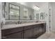 Spacious bathroom features double sinks, dark wood cabinets, and a view of the walk-in shower at 14571 W Wethersfield Rd, Surprise, AZ 85379
