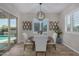 Elegant dining room with a modern chandelier, a sliding glass door with a view of the backyard pool at 14571 W Wethersfield Rd, Surprise, AZ 85379