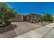 Charming home with a two-car garage and attractive brick-paved driveway, enhanced by well-maintained landscaping at 14571 W Wethersfield Rd, Surprise, AZ 85379