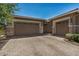 Spacious three-car garage with a brick-paved driveway offering ample parking, complemented by neat landscaping at 14571 W Wethersfield Rd, Surprise, AZ 85379
