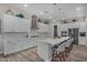 Contemporary kitchen with white cabinetry, stainless steel appliances, island with seating, and decorative backsplash at 14571 W Wethersfield Rd, Surprise, AZ 85379