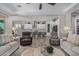 Cozy living room showcasing modern furniture, a ceiling fan, and an open layout leading to the kitchen and dining area at 14571 W Wethersfield Rd, Surprise, AZ 85379