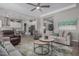 Inviting open-concept living room with neutral tones, a ceiling fan, comfortable seating, and an open view of the kitchen at 14571 W Wethersfield Rd, Surprise, AZ 85379
