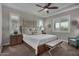 Serene main bedroom featuring a tray ceiling, a large bed, bench, and decorative wall accents at 14571 W Wethersfield Rd, Surprise, AZ 85379