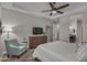 Comfortable main bedroom with sitting area, dresser with TV, and ensuite bathroom access at 14571 W Wethersfield Rd, Surprise, AZ 85379