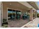 Covered patio featuring outdoor dining set and an extended patio with landscaped green space and a pool at 14571 W Wethersfield Rd, Surprise, AZ 85379
