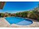 Beautiful pool with travertine tile decking and lush landscaping, complete with fountain features at 14571 W Wethersfield Rd, Surprise, AZ 85379