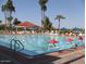 Community outdoor pool with umbrellas and lounge chairs are surrounded by well-maintained landscaping at 1633 E Lakeside Dr # 154, Gilbert, AZ 85234