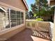 Cozy, tiled patio with a view of landscaped greenery and neighboring homes through a latticed fence at 1633 E Lakeside Dr # 154, Gilbert, AZ 85234