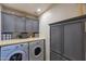Bright laundry room with front-loading washer/dryer and storage cabinets at 16461 W Central St, Surprise, AZ 85388