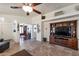 Open living room with tile flooring, a ceiling fan, and an entertainment center at 16461 W Central St, Surprise, AZ 85388