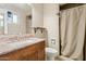 Bathroom features a granite countertop sink and a shower behind a shower curtain at 1649 W Royal Palm Rd, Phoenix, AZ 85021