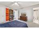 This bedroom features a ceiling fan and a bookshelf, in addition to an ensuite bathroom at 1649 W Royal Palm Rd, Phoenix, AZ 85021