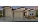 Inviting single-Gathering home displaying a neutral color palette, well-manicured lawn, and a spacious three car garage at 16784 W Whispering Wind Dr, Surprise, AZ 85387