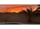 Sunset view of backyard with pool and desert landscaping with beautiful sky colors at 1761 N Hester Trl, Casa Grande, AZ 85122