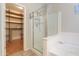Bathroom with a glass shower, bathtub, and walk-in closet with wood shelves and racks at 1761 N Hester Trl, Casa Grande, AZ 85122