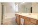 Bathroom with double sinks, a bathtub, and shower featuring neutral color palette at 1761 N Hester Trl, Casa Grande, AZ 85122