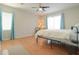 Light and airy bedroom with wood flooring, ceiling fan, and bright blue curtains at 1761 N Hester Trl, Casa Grande, AZ 85122