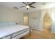 Bright bedroom with a ceiling fan and an entrance to the main bathroom featuring a tub at 1761 N Hester Trl, Casa Grande, AZ 85122