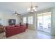 Bright living room with tile flooring, ceiling fan, and sliding glass doors to the pool area at 1761 N Hester Trl, Casa Grande, AZ 85122