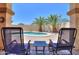 Backyard with a private pool and two lounge chairs under a covered patio with palm trees at 1761 N Hester Trl, Casa Grande, AZ 85122