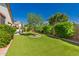Well-maintained backyard with manicured lawn, mature trees, and a relaxing patio area at 17825 W Lincoln St, Goodyear, AZ 85338